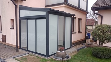 Hliníková pergola kotvená k domu - střecha polykarbonát, zasklená